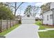 Detached two-car garage with long driveway, manicured lawn and partial view of the main house at 61 Main St, Moreland, GA 30259