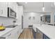 Bright kitchen with white cabinets, a large island, stainless steel appliances, and stylish lighting at 61 Main St, Moreland, GA 30259