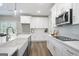 A modern kitchen featuring white cabinets, stainless steel appliances, and a large farmhouse sink at 61 Main St, Moreland, GA 30259