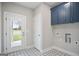 Well-lit laundry room featuring stylish tile flooring, blue cabinetry, and convenient utility connections at 61 Main St, Moreland, GA 30259