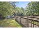 View of large wooden deck with railing, leading to outbuildings and a storage shed in a wooded setting at 3580 Dorris Cir, Douglasville, GA 30135