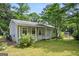 Cozy home with light siding, white trim, a covered porch, and a lush green lawn in a tranquil, wooded setting at 3580 Dorris Cir, Douglasville, GA 30135