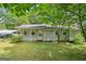 Charming single-story home with light gray siding, a covered front porch, and a well-maintained lawn with mature shade trees at 3580 Dorris Cir, Douglasville, GA 30135