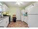 A kitchen with white appliances, cabinets, countertops, and a stacked washer and dryer at 3580 Dorris Cir, Douglasville, GA 30135