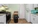 A kitchen with white appliances, cabinets, countertops, and a stacked washer and dryer at 3580 Dorris Cir, Douglasville, GA 30135