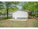 Back exterior of home with stone foundation, lawn, and garden bed at 3118 Rockbridge Rd, Avondale Estates, GA 30002