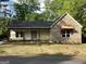 Charming brick and siding home with covered front porch and newly installed lawn at 135 Church St, Palmetto, GA 30268