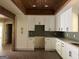 Bright kitchen boasting white cabinetry, a gray backsplash, ample counter space, and rustic wood beams overhead at 135 Church St, Palmetto, GA 30268