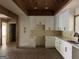 Bright kitchen featuring white cabinets with black hardware, wood ceiling beams, and a window over the sink at 135 Church St, Palmetto, GA 30268