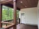 Cozy outdoor porch featuring a stained wood deck, railing, and ceiling with recessed lights at 135 Church St, Palmetto, GA 30268