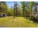 Spacious backyard featuring lush green grass, mature trees, and a shed at 231 Breckenridge Ln, Powder Springs, GA 30127