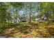 View of a large backyard with house, deck, and plentiful trees at 231 Breckenridge Ln, Powder Springs, GA 30127