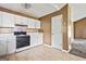Compact kitchen with white cabinets, white countertops, essential appliances, and tile flooring at 231 Breckenridge Ln, Powder Springs, GA 30127