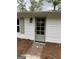 A white cottage home features a glass back door with white trim, a brick path, and pine straw landscaping at 854 Clearwater Rd, Sharpsburg, GA 30277