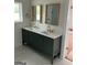 Bathroom featuring double sink vanity with white countertop, green cabinets, and gold fixtures at 854 Clearwater Rd, Sharpsburg, GA 30277