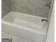 Bathroom featuring a white porcelain bathtub with white tile surround and gold fixtures at 854 Clearwater Rd, Sharpsburg, GA 30277
