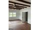 Light-filled room with wood-look floors and wood beam ceiling, next to an ensuite bathroom at 854 Clearwater Rd, Sharpsburg, GA 30277