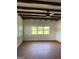 This large living room has laminate floors, white walls, big windows, and exposed rafters at 854 Clearwater Rd, Sharpsburg, GA 30277