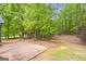 Large backyard featuring a brick patio, garden area, and mature trees at 40 Kelsey Way, Palmetto, GA 30268