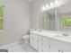 Bathroom with double sinks, white cabinets and tile floors at 40 Kelsey Way, Palmetto, GA 30268