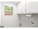 Clean laundry room with white cabinets and a window at 40 Kelsey Way, Palmetto, GA 30268