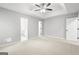 Spacious main bedroom featuring neutral walls and carpeting, a ceiling fan, and multiple doorways at 40 Kelsey Way, Palmetto, GA 30268