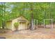 Exterior of a bright yellow outbuilding with a porch and swing in a wooded setting at 40 Kelsey Way, Palmetto, GA 30268