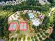 Stunning aerial view showcasing a community center featuring a pool, splash pad, playground, and tennis courts at 976 Buckhorn Bnd, Locust Grove, GA 30248