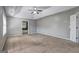 Spacious bedroom featuring a tray ceiling, ceiling fan and neutral carpeting at 976 Buckhorn Bnd, Locust Grove, GA 30248