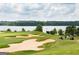 Picturesque golf course view featuring lush green fairways, sand traps, and a glimpse of the lake at 976 Buckhorn Bnd, Locust Grove, GA 30248