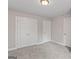 A bright bedroom with three doors and neutral carpet at 115 Oak Road, Locust Grove, GA 30248