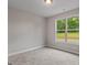Cozy bedroom features plush carpeting, neutral walls and a large window that brings in the outdoors at 115 Oak Road, Locust Grove, GA 30248