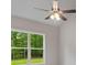 Bedroom boasts a modern ceiling fan and a large window to bring in the natural light at 115 Oak Road, Locust Grove, GA 30248