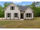 The exterior of this charming white home is enhanced by dark shutters and lush green lawn at 115 Oak Road, Locust Grove, GA 30248