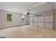 Spacious two-car garage with concrete floors, overhead lighting, and windows for natural light at 115 Oak Road, Locust Grove, GA 30248