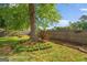 Green backyard featuring grass and trees behind a wooden fence with a raised garden bed at 235 Castlegate Cir, Carrollton, GA 30116