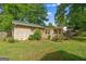 Backyard view showing a brick home, and a green metal roof, a porch, and mature trees at 235 Castlegate Cir, Carrollton, GA 30116
