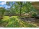 Spacious backyard with mature trees, a fire pit, patio set, and fenced perimeter at 235 Castlegate Cir, Carrollton, GA 30116