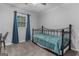Neutral bedroom with large window and black iron bed frame with teal bedding at 235 Castlegate Cir, Carrollton, GA 30116