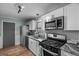 Modern kitchen with stainless steel appliances, granite countertops, hexagon backsplash and white cabinets at 235 Castlegate Cir, Carrollton, GA 30116