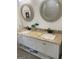 Bathroom vanity featuring dual sinks, granite countertop, stylish fixtures, and round mirrors at 1962 Markone Nw St, Atlanta, GA 30318