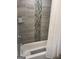 Modern tiled bathtub with a shower, a shower curtain, and toiletries on the shelf at 1962 Markone Nw St, Atlanta, GA 30318