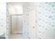 Bathroom featuring a walk-in shower with glass doors, floral wallpaper, and white tiled floors at 260 Emerald Lake Dr, Fayetteville, GA 30215