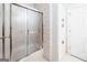Bathroom featuring a tub with sliding doors, floral wallpaper, and a storage closet at 260 Emerald Lake Dr, Fayetteville, GA 30215