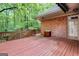 Large wooden deck featuring a brick exterior, a sink, and views of the surrounding woods at 260 Emerald Lake Dr, Fayetteville, GA 30215