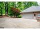 Spacious two-car garage featuring a large driveway and mature trees at 260 Emerald Lake Dr, Fayetteville, GA 30215