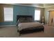 Comfortable main bedroom with plush carpeting, a blue accent wall, and two windows at 6974 Chilkat Sw Ct, South Fulton, GA 30331
