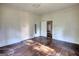 Empty bedroom with wood flooring, natural light, and a doorway to another room at 2228 Emory Sw St, Covington, GA 30014