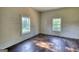 Empty bedroom featuring wood flooring, two windows, and natural light at 2228 Emory Sw St, Covington, GA 30014