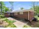 Rear exterior of a brick home with a patio, windows, and mature trees at 322 E Rhinehill Rd, Atlanta, GA 30315